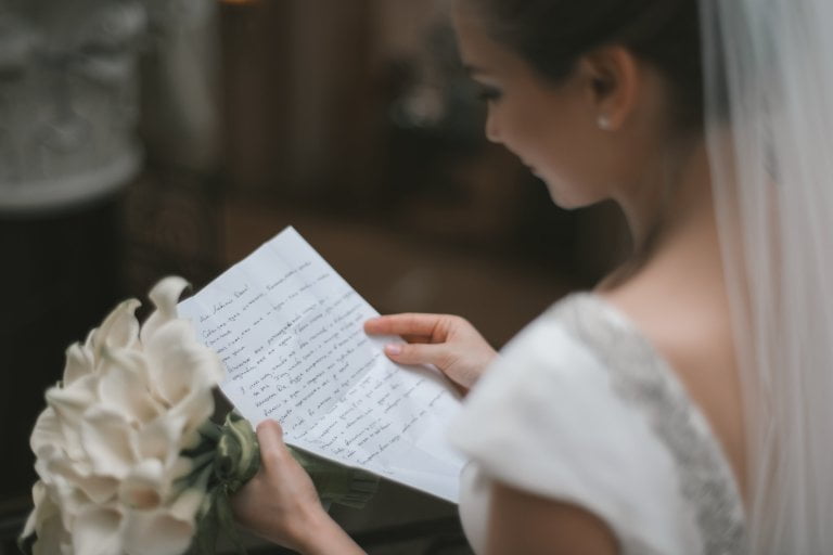 Candid over the shoulder photo of bride reading a letter.